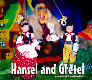 Boy and Girl marionettes stand in front of the Gingerbread Witch.